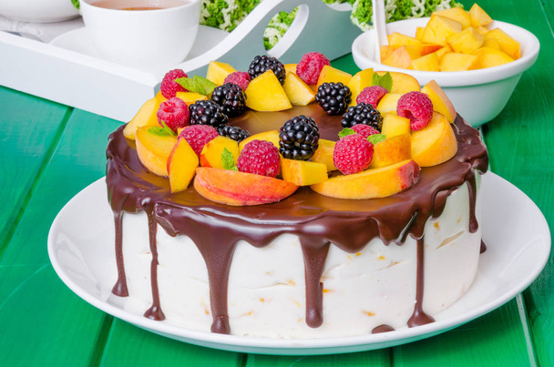Vanille-Mousse-Kuchen mit Pfirsichen und Schokoglasur - Foto, Bild