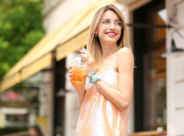 Young woman with cup of tasty lemonade outdoors - Photo, image