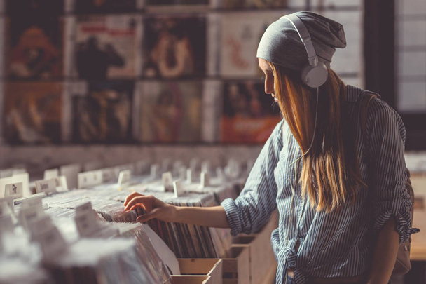 Aantrekkelijk meisje in een platenzaak vinyl - Foto, afbeelding