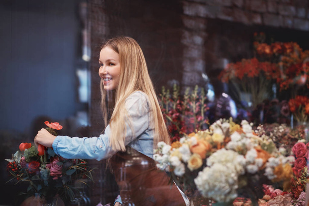 Hymyilevä kukkakauppias töissä myymälässä
 - Valokuva, kuva