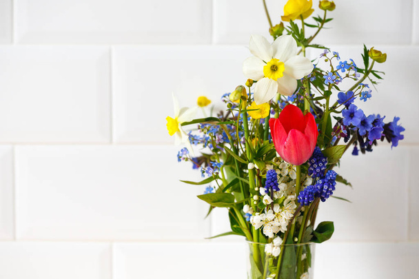 spring bouquet of wild flowers in a glass on a white background. House interior - Foto, Imagem
