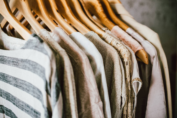 Colección de ropa de moda en colores beige, vestidos de diseñador colgando en el rack de primer plano
 - Foto, Imagen