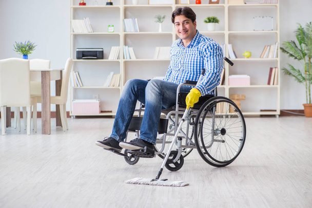 Uomo disabile sulla sedia a rotelle pulizia casa - Foto, immagini