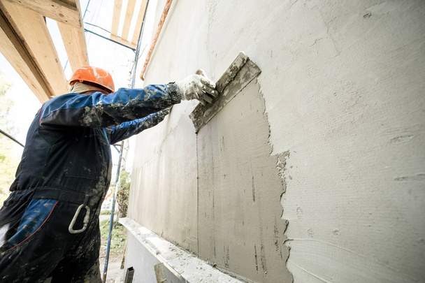 Working with a spatula, preparing the walls for tiling - 写真・画像
