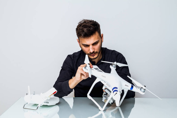 Young Man setting up a drone for first fly indoor - Foto, Bild