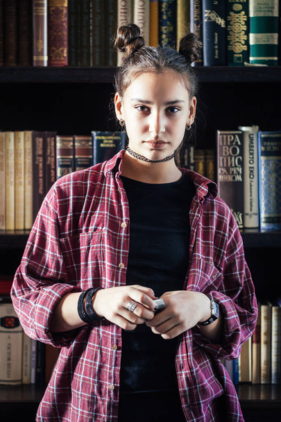 photo of young stylish brunette woman with hairstyle posing at library - 写真・画像