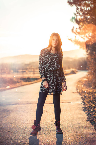 photo of young cheerful brunette woman in dress outdoor in sunset light - Zdjęcie, obraz