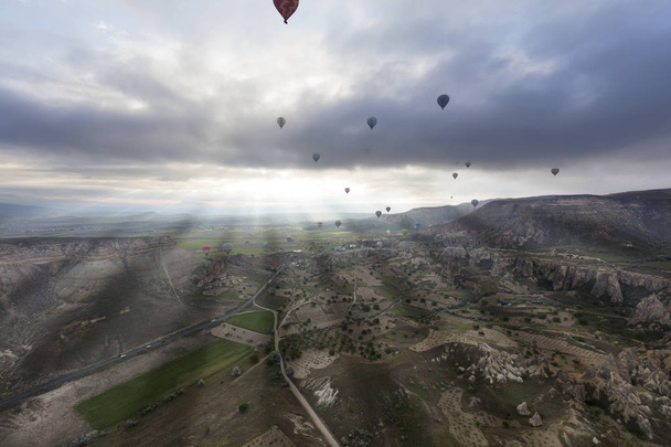 Die Berge Kappadokiens bestechen durch ihre Nacktheit und Offenheit. Luftballons steigen über sie auf. - Foto, Bild