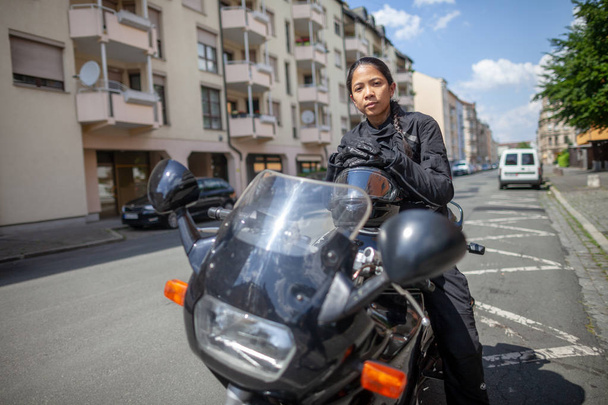 Nő egy motorkerékpár egy fekete bukósisak - Fotó, kép