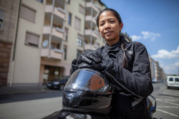 Frau mit schwarzem Helm auf Motorrad - Foto, Bild