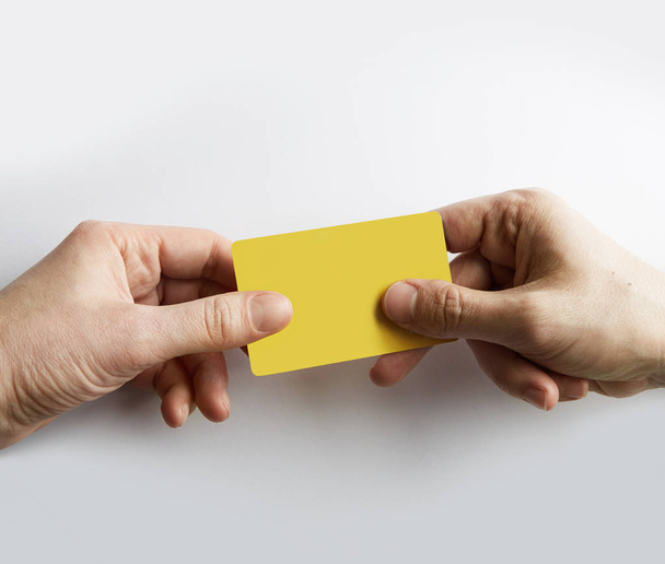 Closeup of male hand giving empty yellow color credit card to waiter - Fotoğraf, Görsel
