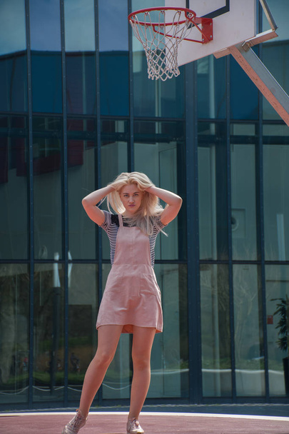 ξανθό κορίτσι κοντά σε ένα κτίριο του καθρέφτη - Φωτογραφία, εικόνα