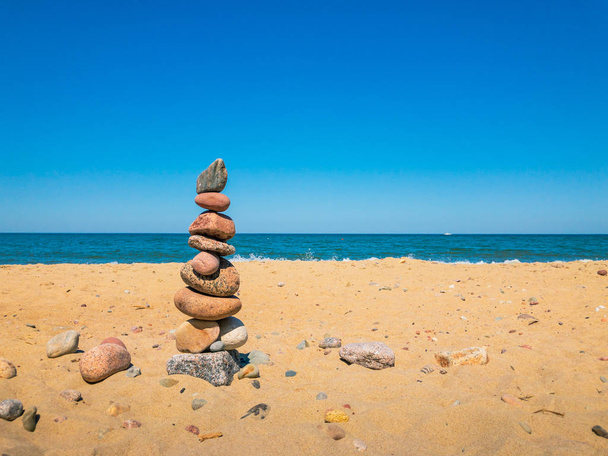 Kivet pyramidissa seistä hiekkarannalla
 - Valokuva, kuva