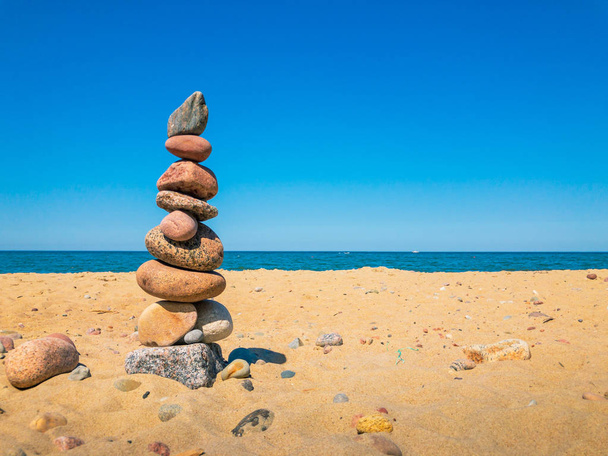 Πέτρες στην πυραμίδα σταθεί πάνω στην αμμώδη παραλία - Φωτογραφία, εικόνα