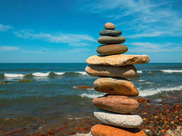 Piedras en la pirámide de pie en la playa de arena
 - Foto, Imagen