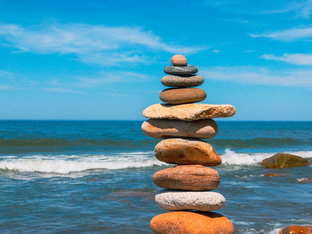 Piedras en la pirámide de pie en la playa de arena
 - Foto, imagen