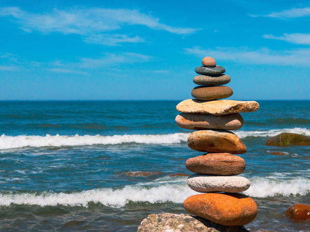 Piedras en la pirámide de pie en la playa de arena
 - Foto, Imagen