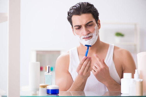 Jung gut aussehend mann rasieren früh am morgen bei zuhause - Foto, Bild