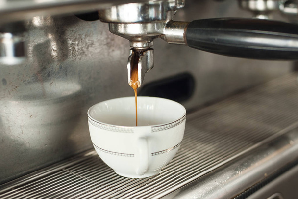 Barista robi espresso z klasycznym włoskim ekspresem do kawy z parą wodną w tle. - Zdjęcie, obraz