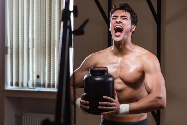 Man with nutrient supplements in sports gym - Photo, Image