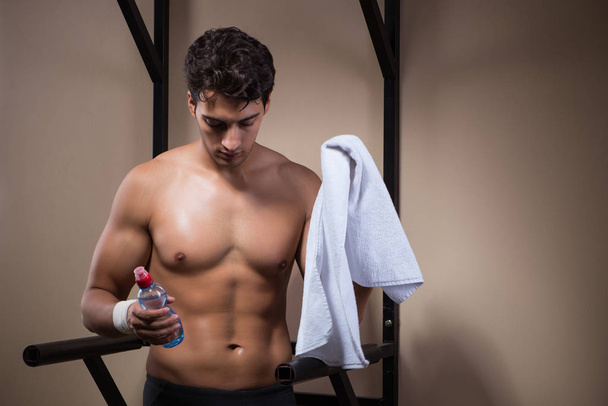 Thirsty man drinking water in sports gym - Foto, Bild