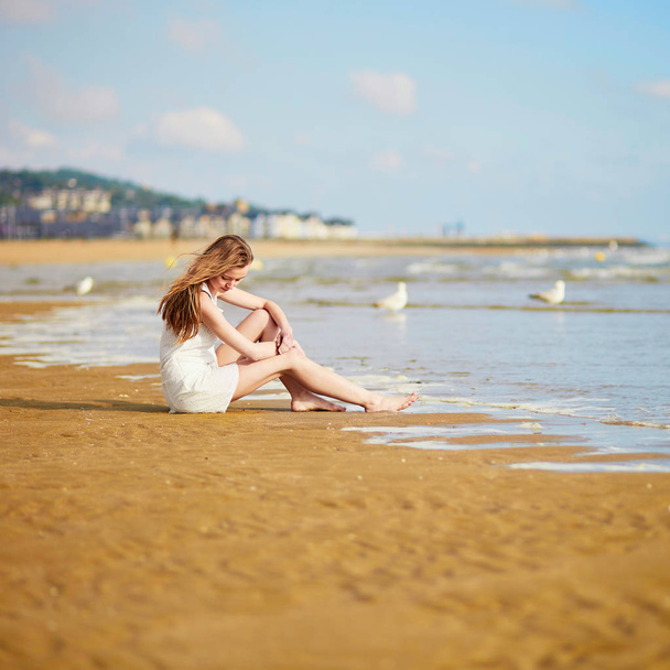 Beautiful young woman enjoying her vacation by ocean or sea. People on sea vacation concept - Foto, imagen