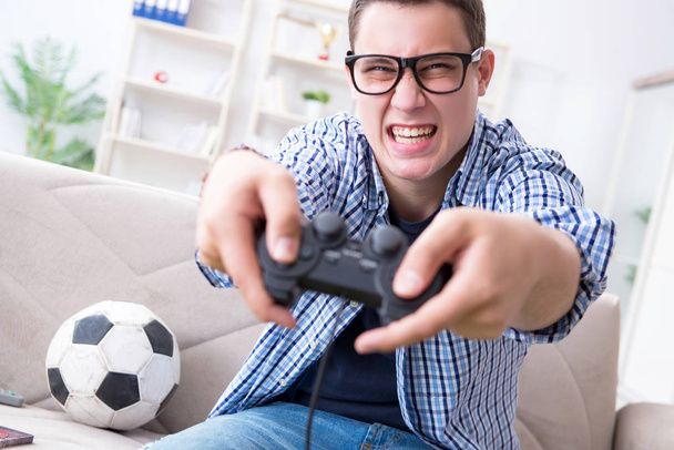 若い男は自宅でコンピュータゲームをプレイ - 写真・画像