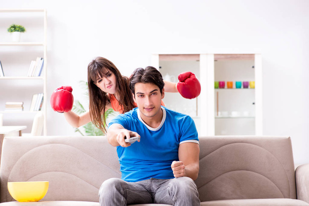 A feleség boldogtalan, hogy a férj bokszot néz. - Fotó, kép
