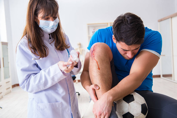 Ποδόσφαιρο ποδοσφαιριστής επισκέπτονται γιατρό μετά τον τραυματισμό - Φωτογραφία, εικόνα