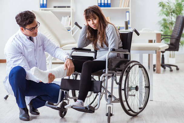 Männlicher Arzt untersucht Patientin im Rollstuhl - Foto, Bild