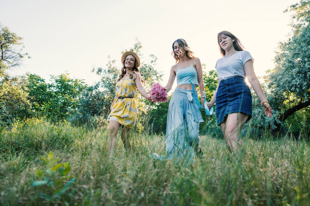 Троє дівчат друзі на відкритому повітрі в парку або лісі
 - Фото, зображення