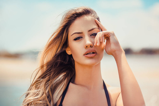 Portret van jonge prachtige brunette vrouw op strand - Foto, afbeelding