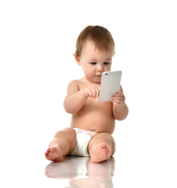Infant child baby girl toddler playing with mobile cellphone happy smiling - Fotó, kép