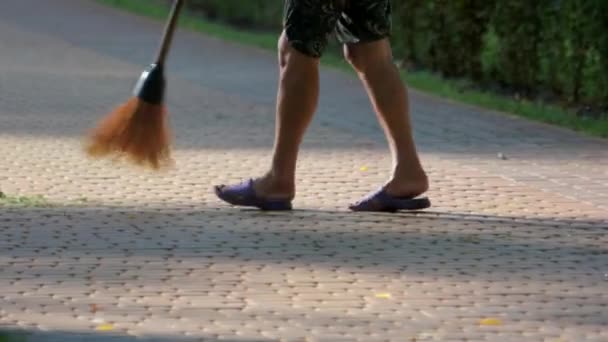 Sweeping cut grass from cobblestone pavement. - Footage, Video