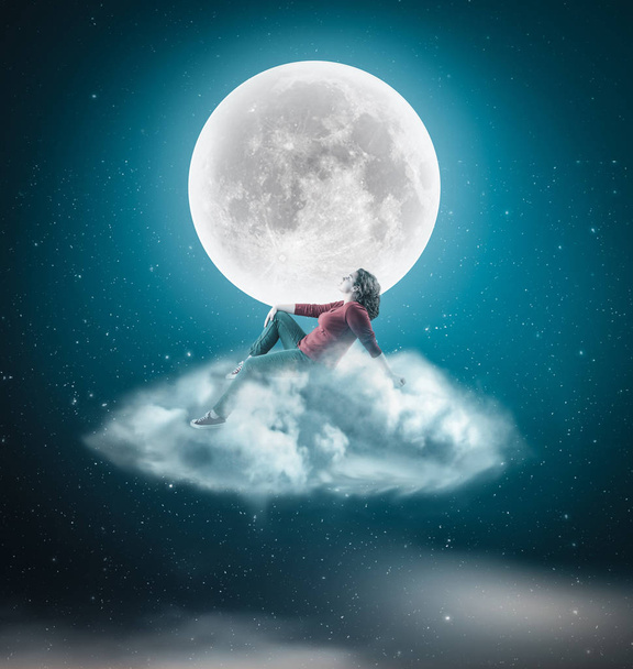 Femme assise sur un nuage et admire la lune dans la nuit
. - Photo, image