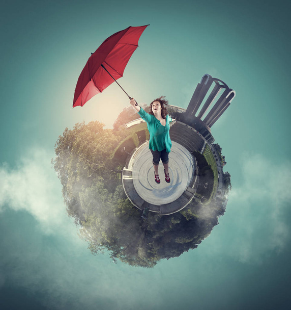 Woman getting off the ground with an umbrella. 360 degree view globe - Photo, Image