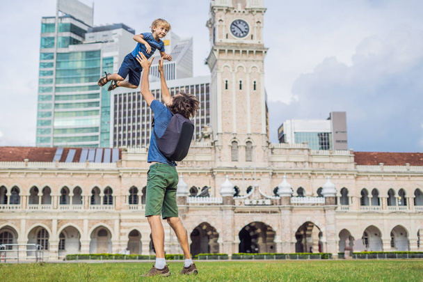Dad and son on background of Merdeka square and Sultan Abdul Samad Building. Traveling with children concept. - 写真・画像