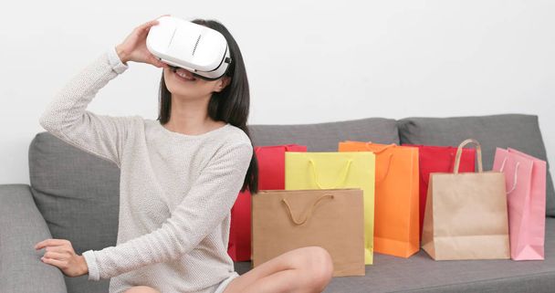 Frau nutzt Virtual-Reality-Gerät für Einkaufserlebnis zu Hause  - Foto, Bild