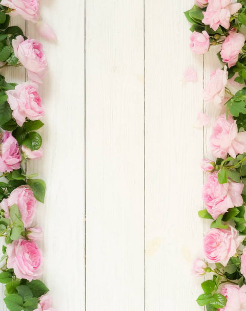 Bouquet frame of beautiful pink roses on white wooden background.Top view.Copy space - 写真・画像