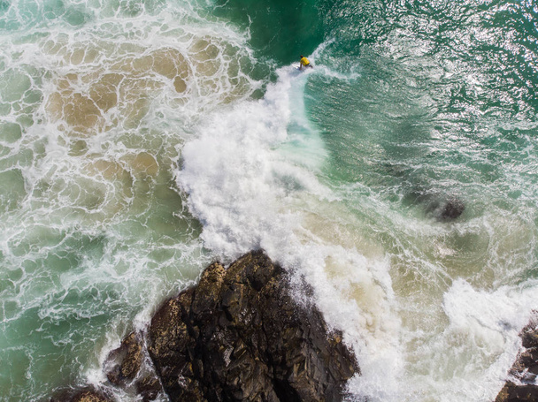 Взгляд с воздуха на неизвестного серфера, покоряющего волны - Фото, изображение