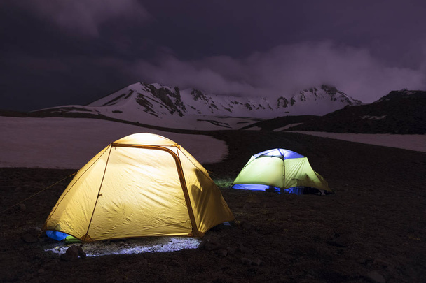 Ночь перед восхождением - у подножия Эрджиес Даг в центральной Анатолии, Турция, сияют палатки туристов
. - Фото, изображение