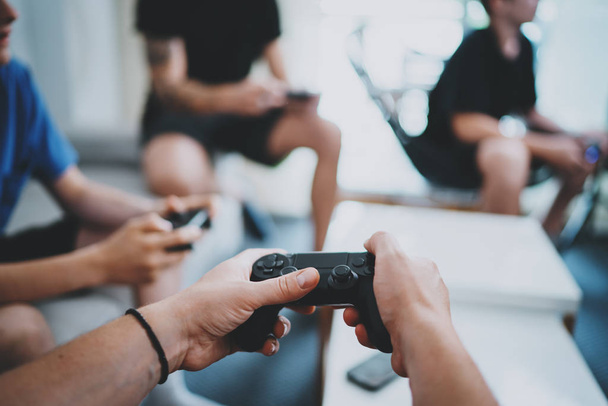 Friendship, technology, games and relaxing time at home concept - close up of male friends playing video games at living room. - Photo, Image