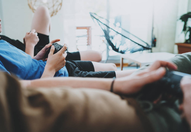 Friendship, technology, games and relaxing time at home concept - close up of male friends playing video games at living room. - Fotó, kép