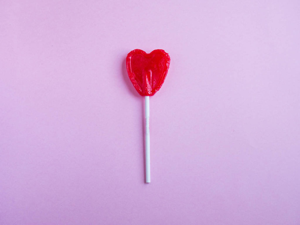 Red heart lollipop on pink background - Photo, image