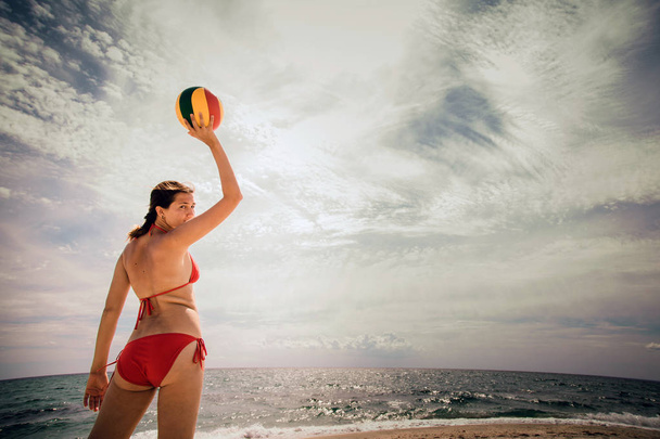 healthy young woman laughing with beachball while on the beach in summer. vacation, sport and people concept - young woman with ball playing volleyball - Photo, Image