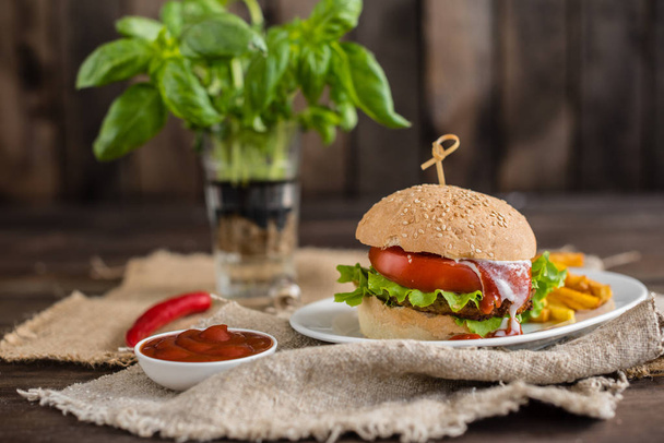 Sabrosa hamburguesa con carne y verduras sobre un fondo oscuro. Comida rápida. Se puede utilizar como fondo
 - Foto, imagen
