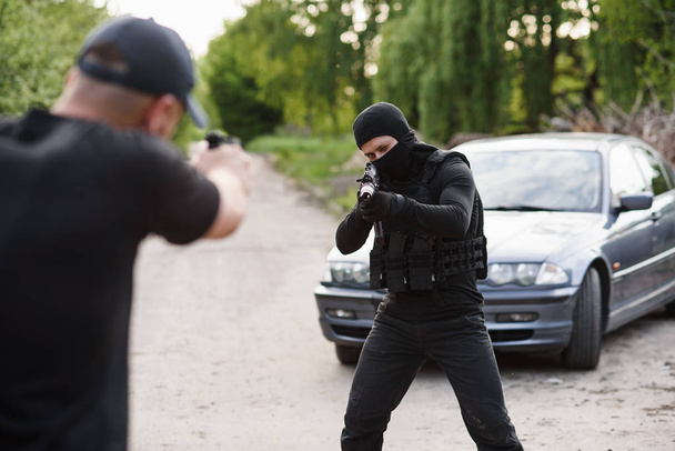 Shootout between a police officer and a offender. Stop Terrorism and Crime. The police officer and the terrorist are aiming each other. - Foto, Bild