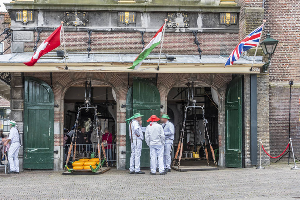 das alte Gebäude der Gewichte des Käsemarktes von Alkmaar und die Einheimischen kleideten sich in der alten Weise. Niederlande Holland - Foto, Bild