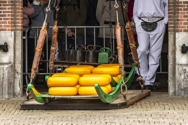 Käse, der auf dem Markt von Alkmaar so gewogen wird, wie er es seit vielen Jahren tut. Niederlande Holland - Foto, Bild