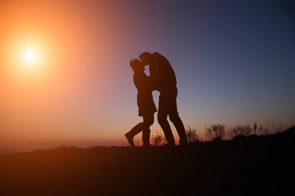 хлопець силует і дівчина на красивому заході сонця тримає руки
 - Фото, зображення